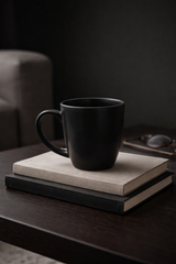 Black mug on a stack of books with a dark background