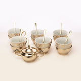 Golden tea cup with sugar pot and spoon